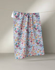 Floral patterned skirt hanging on a line against a plain background