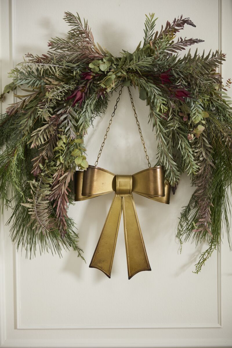 Aged brassy metal Bow Wreath with gold chain, decorative holiday bow for door or wreath display, vintage-inspired holiday décor.
