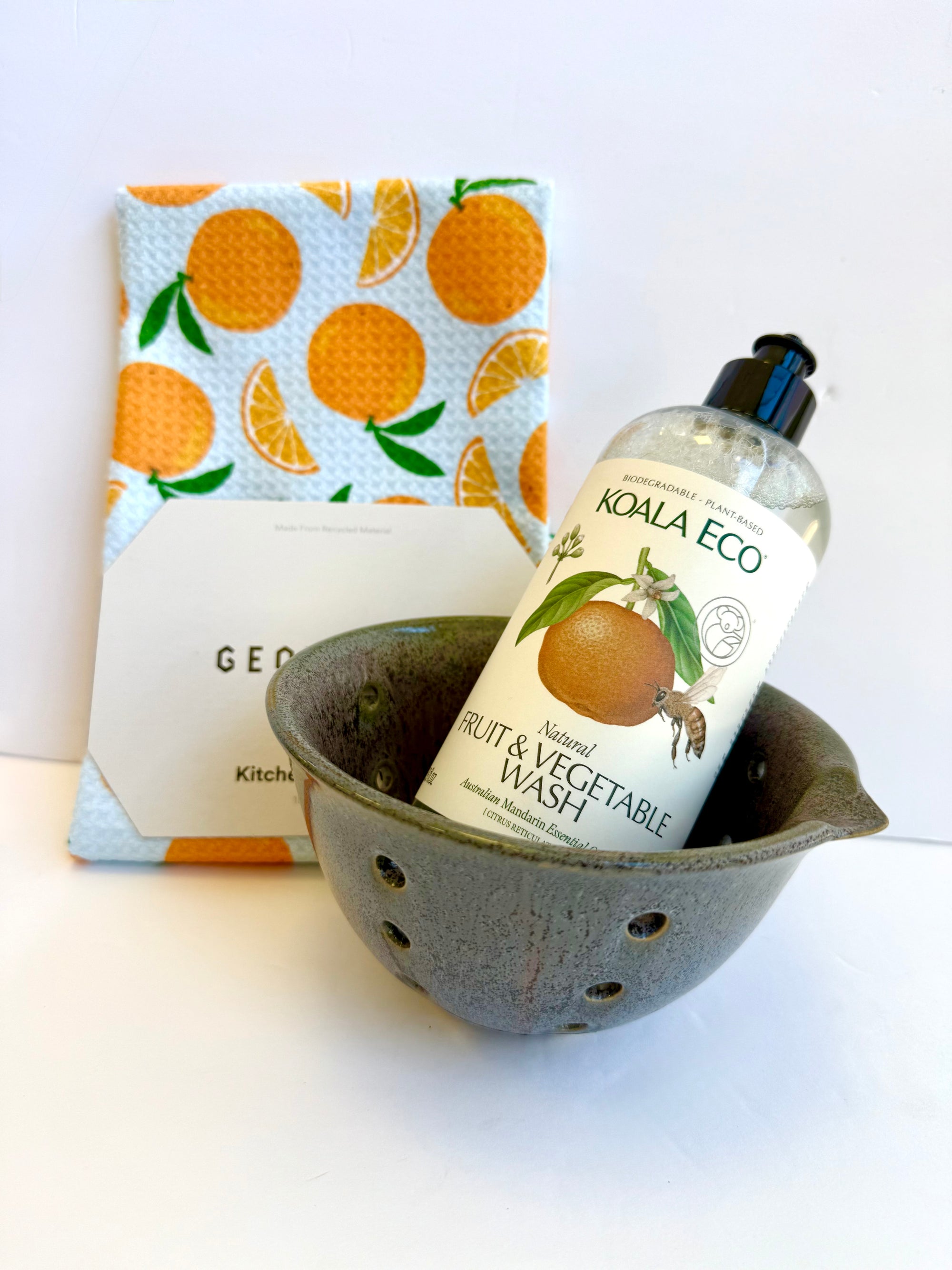 Luxury citrus kitchen gift basket featuring mandarin fruit wash, glazed ceramic berry bowl, and orange waffle tea towel. Sustainable, handcrafted, and perfect for hostess or housewarming gifts.