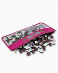 Pink carrying case with transparent lid containing small square items on a white background