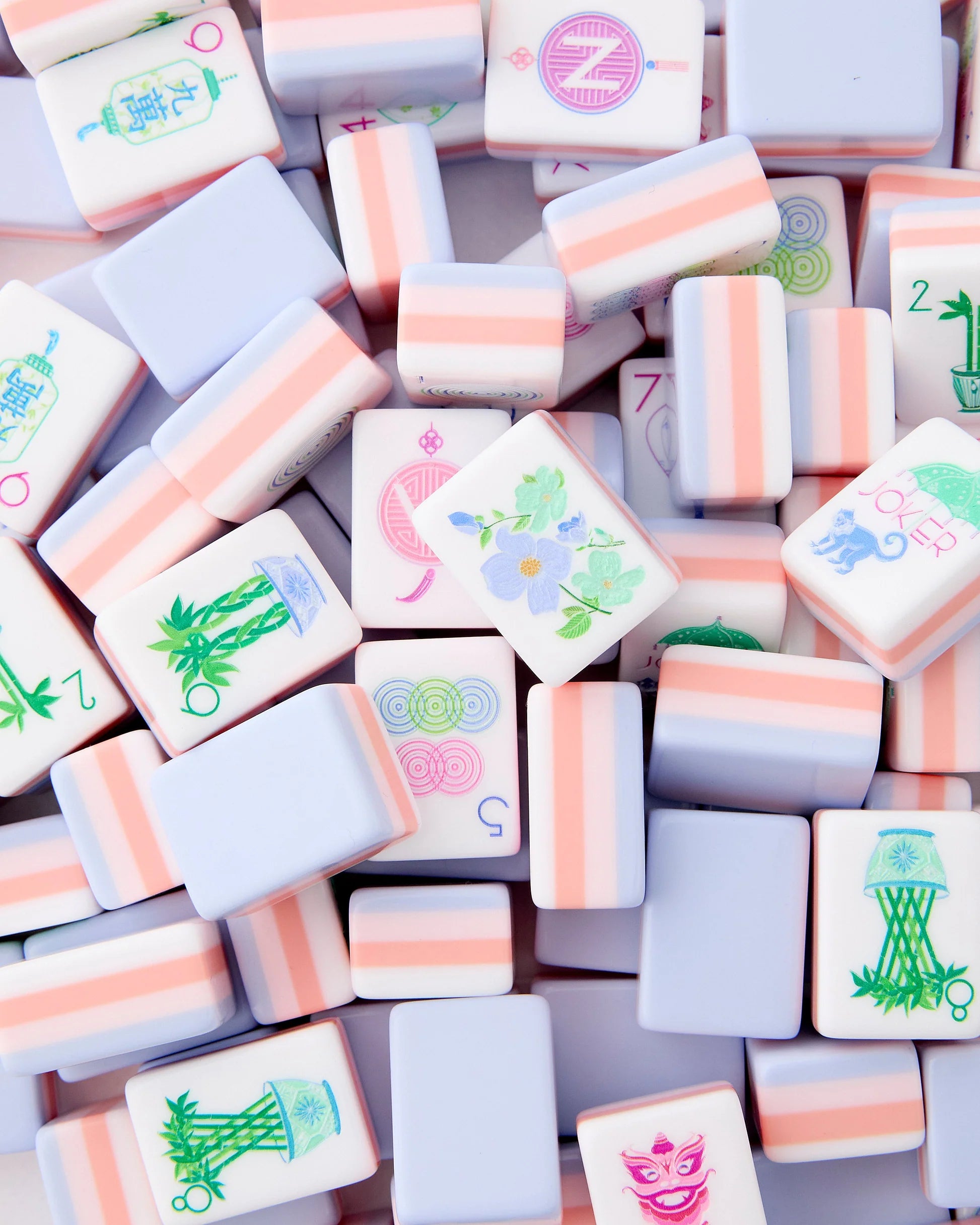 Luminaire Mahjong Tiles in coral and pink with periwinkle backing displayed on table