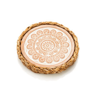 Terracotta warming trivet with embossed mandala design in a handwoven kaisa grass basket.
