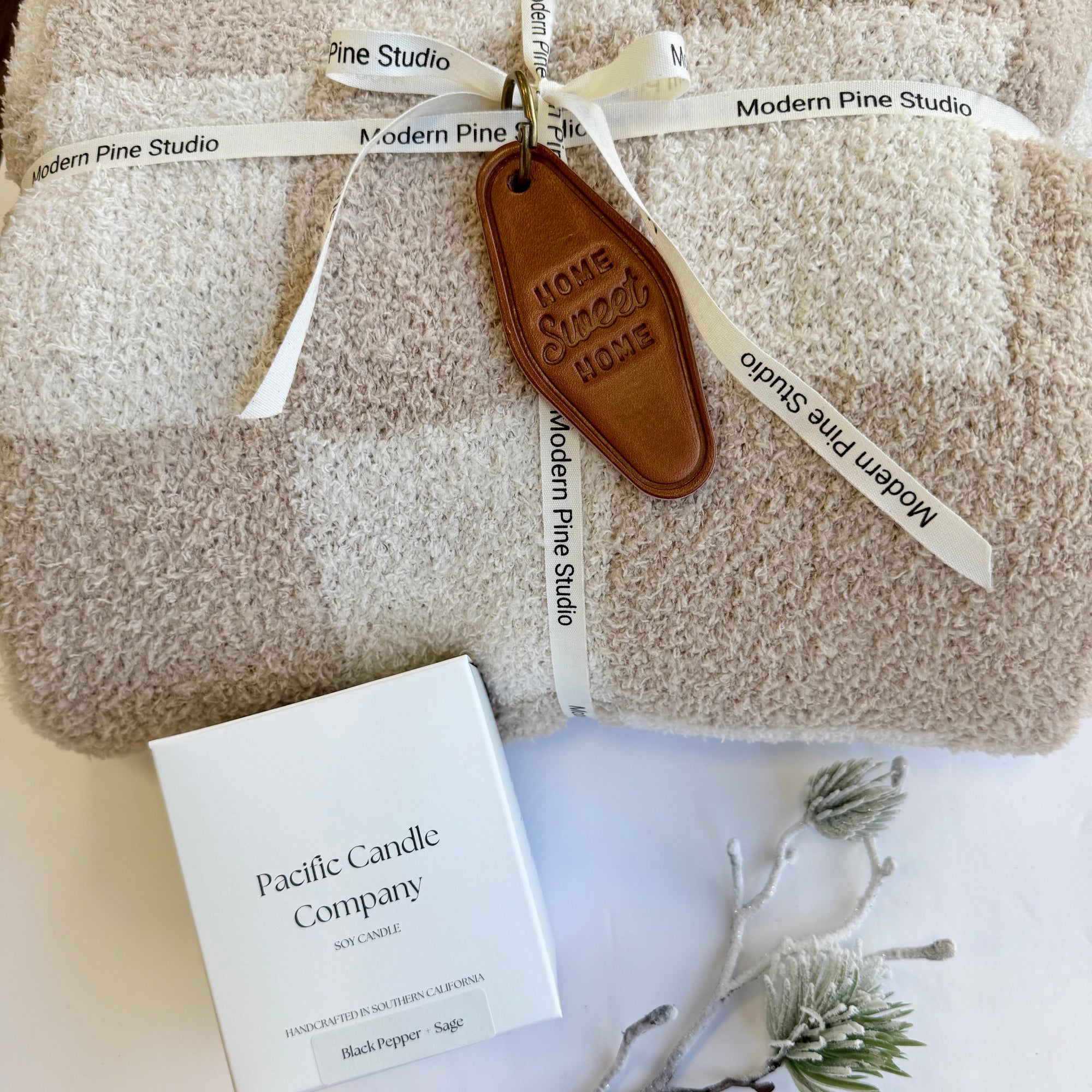 Welcome Home Box featuring a soft blanket, custom “Welcome Home” candle, and leather keychain, beautifully packaged for housewarming or client gifts.